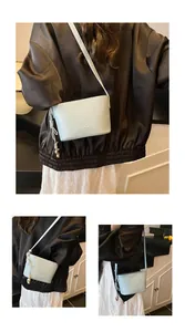 Détail d'un sac seau en cuir bleu clair avec cordon de serrage et breloque sphère en métal