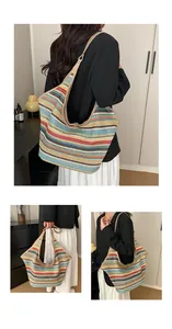 Detail of woven straw tote bag featuring colorful stripes and leather shoulder strap