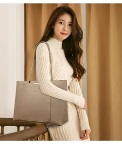 Détail du sac cabas en similicuir grainé taupe avec grande poche avant et logo