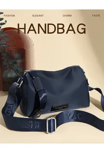 Détail du sac de voyage bleu marine avec large bandoulière à logo et finitions argentées