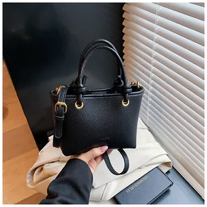Detail of lychee pattern black leather bag with gold hardware and logo embossing