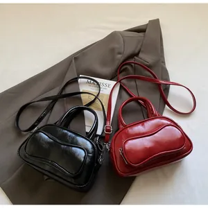 Chic glossy PU leather bowling bag in black and red displayed on a brown jacket