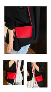 Détail du sac seau rouge avec texture litchi et marquage doré sur blazer noir chic