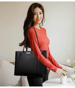 Détail du sac cabas en cuir grainé noir avec barre métallique argentée et logo kangourou