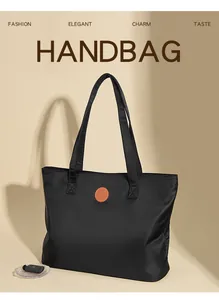Gros plan du sac cabas en nylon noir avec un détail d'écusson logo en cuir marron