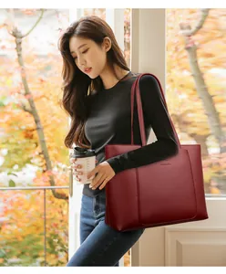Détail du sac fourre-tout en cuir bordeaux avec logo kangourou et bandoulière élégante