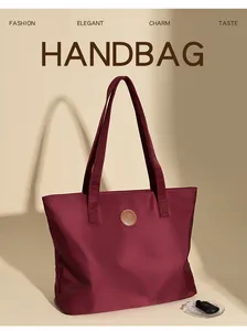 Détail du sac cabas en nylon bordeaux avec un logo circulaire en cuir sur le devant