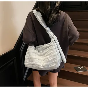 Detailed texture of quilted wavy stitching on a large capacity padded crossbody tote bag