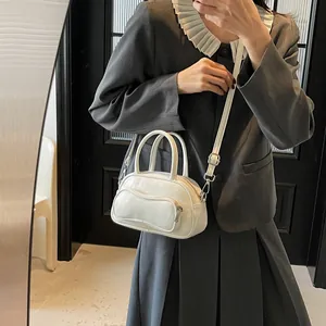 White bowling crossbody bag for women with wave-shaped front pocket and silver hardware