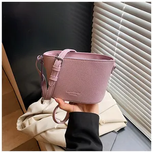 Détail du sac seau lilas en cuir grainé avec une bandoulière réglable et élégante