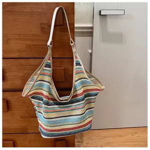 Detail of multi-colored striped woven tote bag with premium cream leather handles