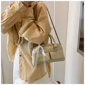 Detail of vintage bowling bag with lace bows and twin front pockets on sage green leather