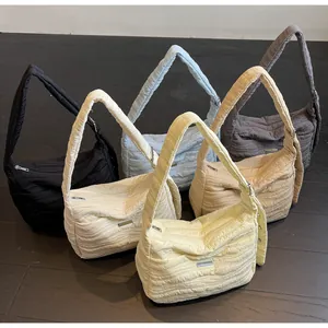 Detailed overhead view of quilted crescent bags in black, white, blue, camel and yellow