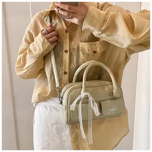 Light green PU leather crossbody bag with lace bows shown in a lifestyle mirror selfie