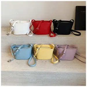 Détail de sacs seaux colorés avec texture grainée et pendentifs en métal en forme de cœur