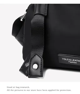 Détail du tissu oxford avec garniture en cuir et anneau en D en métal sur le sac de voyage
