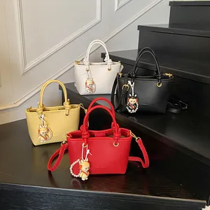 Solid color bucket bags in yellow, white, red, and black with cute pearl pendants