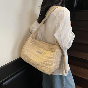 Beige oversized quilted tote bag with wave texture and metal detail on shoulder