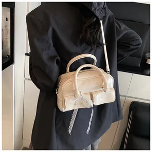Detail view of beige leather handbag with white lace ribbons and double front pockets