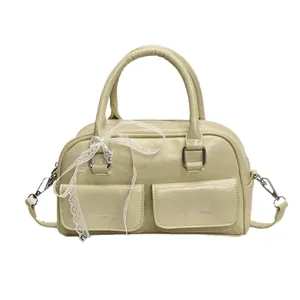 Light green wax leather bowling bag with twin front pockets and a decorative lace ribbon