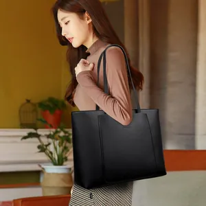 Grand sac cabas noir en cuir pour femme avec texture grainée souple porté à l'épaule