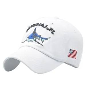 White baseball cap with blue shark embroidery and American flag patch, 45-degree angle