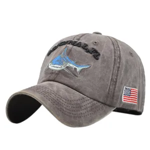 Macro detail of shark embroidery and American flag patch on washed gray baseball cap