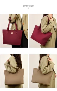 Détail de grands sacs cabas bordeaux et kaki avec des écussons en cuir élégants