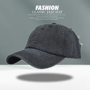 Detail view of distressed dark grey denim baseball cap with vintage frayed hole design