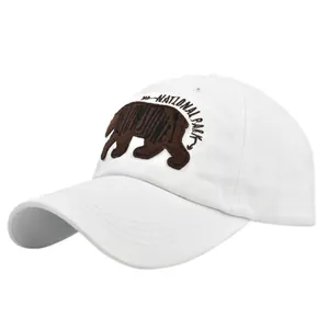 Détail de la broderie ours brun et texte National Park sur cette casquette de baseball blanche
