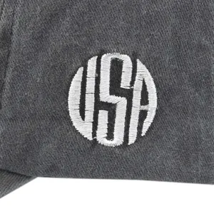 Primer plano del bordado blanco USA sobre la tela gris texturizada de la gorra