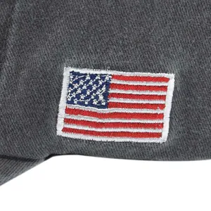 Macro shot of embroidered American flag patch on vintage washed grey cotton cap fabric