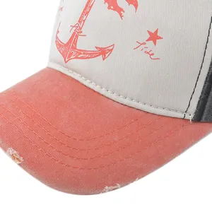 Close-up of distressed brim and anchor print on vintage beige and pink baseball cap