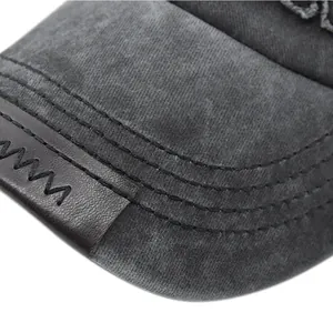 Makro-Detail des gewaschenen schwarzen Canvas-Schirms mit Lederaufnäher und Ziernähten