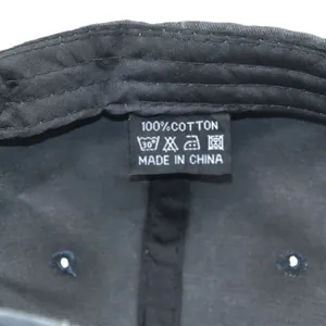 Detail view of the 100% cotton material wash label and interior stitching on black cap