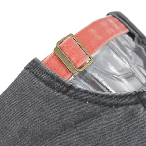 Close-up of vintage bronze buckle with pink velvet strap on a grey baseball cap