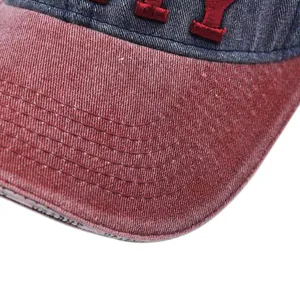Detail of vintage baseball cap with reinforced stitching and red 3D embroidery on washed fabric