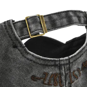 Détail de la casquette vintage en denim gris avec boucle en laiton réglable et broderie