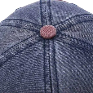 Close-up of vintage navy washed denim baseball cap with contrast crown button and stitching