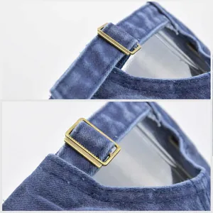Macro detail of the vintage bronze metal slide buckle and stitching on blue baseball cap