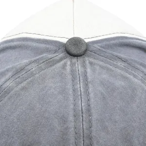 Detailed macro view of the top button and stitching on a distressed washed cotton baseball cap