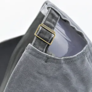 Detail of adjustable metal buckle and fabric texture on a washed gray baseball cap
