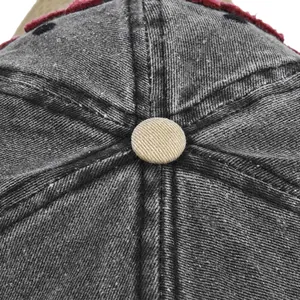 Macro view of vintage washed denim baseball cap top with khaki fabric button and neat stitching