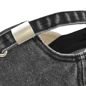 Detail of adjustable metal buckle and dark gray washed denim texture on baseball cap