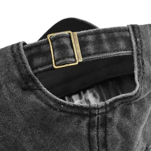 Gros plan détaillé sur la boucle en laiton réglable de la casquette en denim gris foncé