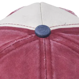 Macro detail of red washed vintage baseball cap with navy blue button and stitching