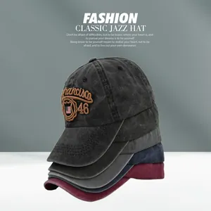 Detailed stacked view of washed cotton baseball caps in dark grey, navy and burgundy