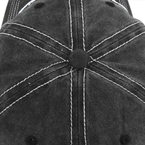Top view of washed black baseball cap showing white contrast stitching and crown button