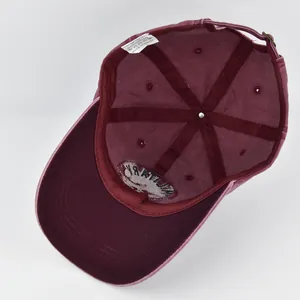 Detail view of burgundy cotton baseball cap showing interior stitching and military embroidery