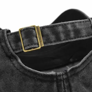 Detailed view of washed denim baseball cap with vintage bronze adjustable metal buckle